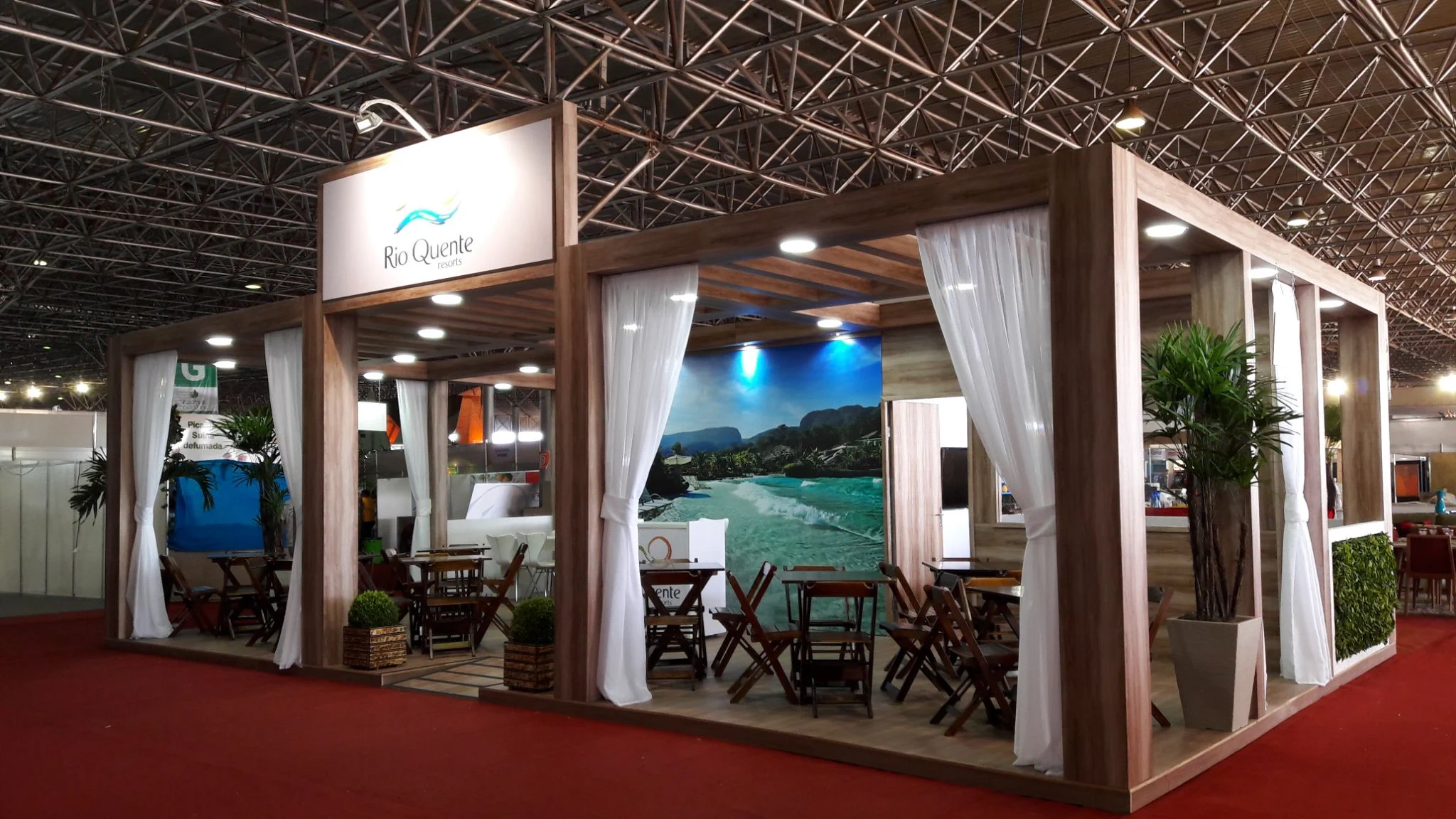 Estande do Rio Quente Resorts com estrutura de madeira e cortinas brancas